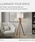 Living room with table lamp featuring walnut tripod base and white linen drum shade next to armchair.