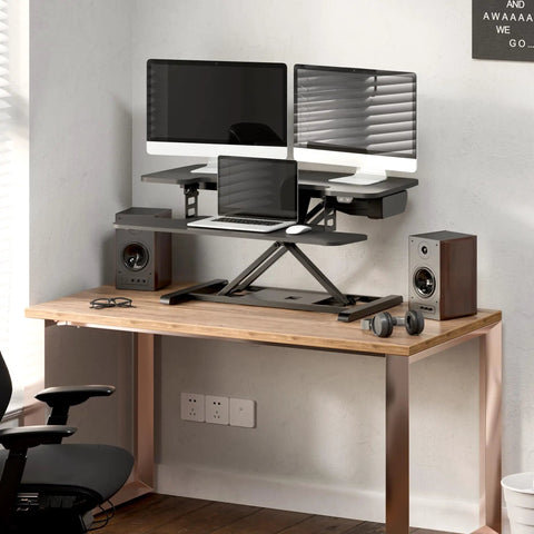 35 Inch Electric Standing Desk Converter With Slick Quiet Lift Height Adjustable Stand Up Riser Dual Monitor And Laptop Setup Wide Keyboard Tray Black Finish on wooden desk, featuring dual monitors and laptop with speakers.