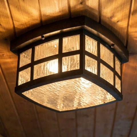 Stonington Outdoor Flush Mount Ceiling Light With 12 Inch Two Light Palladian Bronze Finish, Vintage Close To Ceiling Exterior Fixture For Patio Porch Or Balcony, Water Glass Illumination And Mission Style Old School Charm installed on wooden ceiling.