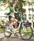 Woman riding a white bicycle in a park, showcasing the use of Beefed Up Heavy Duty 26 Inch Bike Inner Tubes 26 By 1.75 To 2.25 45 57 559