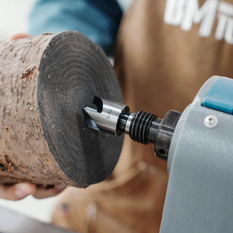 Four Prong Spring Loaded Spur Drive Center 2MT for wood lathe in action, gripping a wood block with 1 inch grip and sharp spurs.