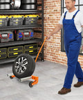 Man using Beefy Heavy Duty Tire Dolly For Garage And Auto Repair Wheel Tire Moving Cart For Transferring Heavy Wheels Safely with orange handle