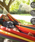 Person lounging in Brazilian Double Hammock For Two People With Tree Straps, Extra Large 240x160 Cm, outdoor setting.