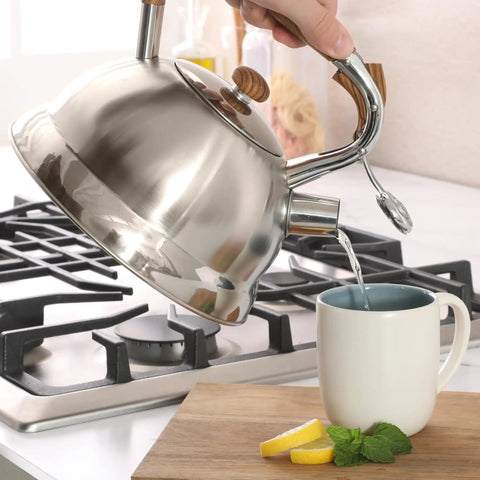Pouring hot water from Stainless Steel 2 Quart Tea Kettle With Wood Handle For Stovetop Whistling Water Pot into cup