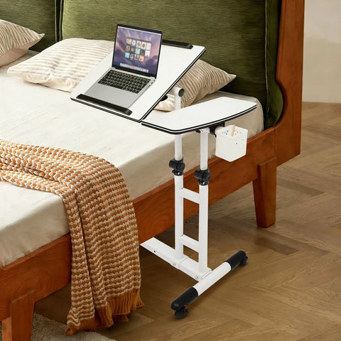 Smooth Rolling Standing Desk Heavy Duty Sit Stand Laptop Cart Adjustable Height Lockable Wheels next to a bed with a laptop.