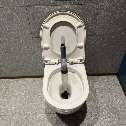 Beast Mode Heavy Duty Toilet Plunger in white toilet, stainless steel high-pressure plunger with real-time pressure display, gray.