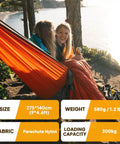 Two people relaxing in Ultra Light Travel Camping Hammock With 300kg Load Capacity 275x140 Cm Parachute Nylon by a lakeside