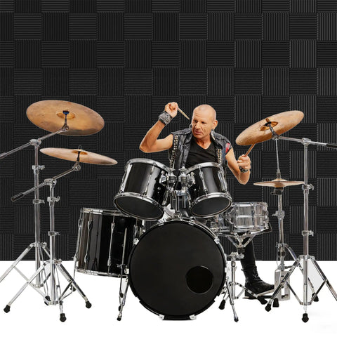 Drummer playing in front of Dope 12 Pack High Density Sound Proof Foam Panels For Walls With Self Adhesive Pads 1 Inch Thick By 12 Inch By 12 Inch Acoustic Panels For Recording Studio Home Theater And Office Noise Cancelling Black.