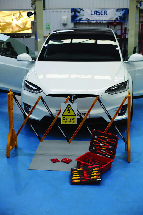 VDE Tool Kit 50 Piece Pro Grade With Sixteen Three-Eighths Inch Drive Sockets shown near electric car setup.