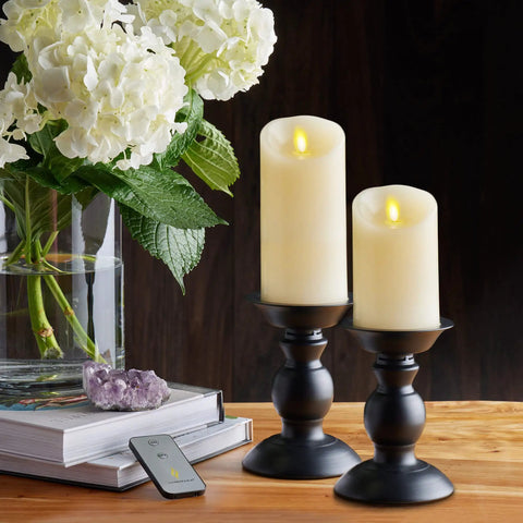 Ivory Scalloped Edge Flameless LED Pillar Candle With Real Wax Look Moving Flame No Mess on black holders beside flowers
