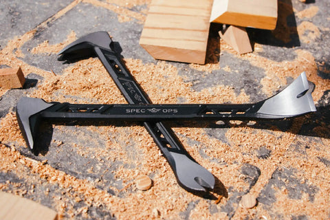Two black Cat's Paw Nail Puller Pry Bars on sawdust with wooden blocks, 11-inch high-carbon steel, demolition tools.