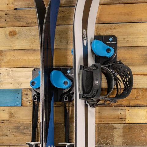 Ultimate Ski and Snowboard Wall Rack With Gravity Locking Design on wooden wall holding skis and snowboard securely