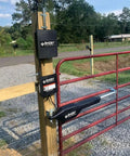 Legit Heavy Duty Automatic Swing Gate Opener Kit With Smart Ready Motor And Dope Long Range Remote Control For Residential Driveway Up To Nine Hundred Pounds mounted on a wooden post with red gate.