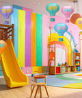 Pastel Grad Party Decorations Kit with 6 printed hot air balloon paper lanterns and 2 tinsel foil fringe curtains in a playroom