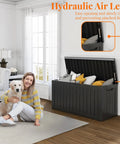 Room with woman and dog, showcasing 90 Gallon Resin Deck Box Lockable Outdoor Storage Box for Patio Cushions Garden Tools and Gear Waterproof Yard Storage Unit That Doubles As A Side Table Storage Bench Or Footstool partially open with items inside.