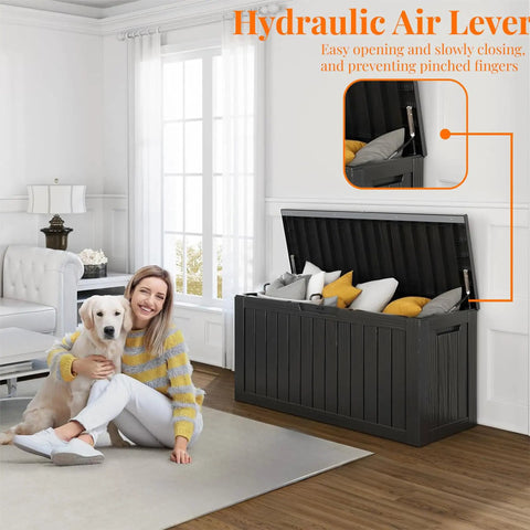 Room with woman and dog, showcasing 90 Gallon Resin Deck Box Lockable Outdoor Storage Box for Patio Cushions Garden Tools and Gear Waterproof Yard Storage Unit That Doubles As A Side Table Storage Bench Or Footstool partially open with items inside.
