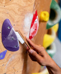 Person using Best Ever Climbing Brush For Chalk And Bouldering Vegan Chalk Bag Friendly Rock Climbing Brush on gym hold