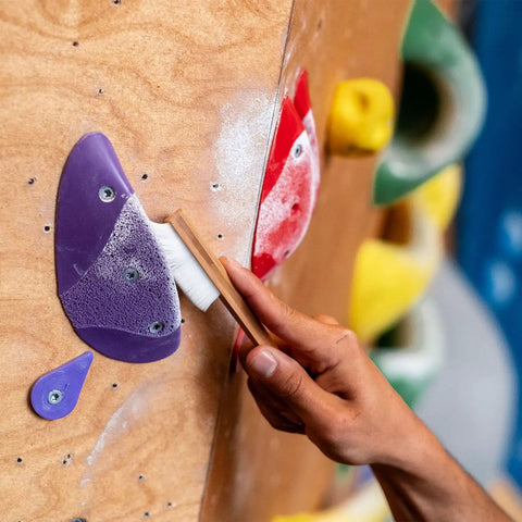 Person using Best Ever Climbing Brush For Chalk And Bouldering Vegan Chalk Bag Friendly Rock Climbing Brush on gym hold