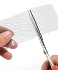 Heavy Duty Grey Window Screen Repair Tape 2 Inch By 30 Foot With Strong Adhesive Fiberglass Mesh Patch being cut with scissors
