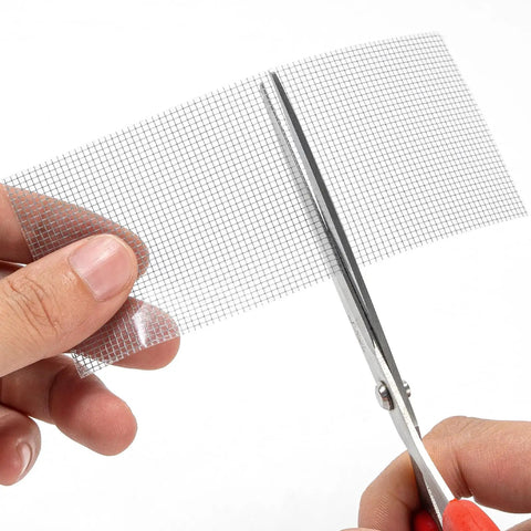 Heavy Duty Grey Window Screen Repair Tape 2 Inch By 30 Foot With Strong Adhesive Fiberglass Mesh Patch being cut with scissors
