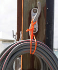 Orange Reusable Rubber Twist Tie bundling cable on dock hook, 18 inch, bendable rubber exterior for DIY projects and organization.