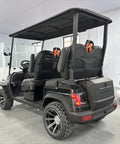 Top Tier Electric Golf Cart 4 Seater Loaded Up With 48V Power Motor Premium Stitched Seats All Terrain Capable Heavy Duty Weekend Warrior View from rear showcasing seats and tires.