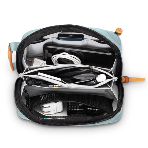 Open Compact Travel Tech Organizer Bag for Cables Chargers and Gadgets with Leather Accents showing contents inside in dusty teal