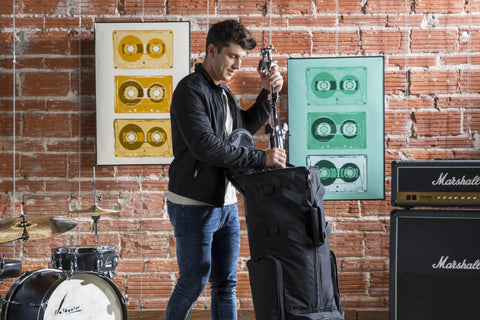 Man using Heavy Duty Rolling Drum Cart With Removable Nylon Gear Bag And Tough Steel Frame to store stage gear.