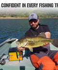 Angler holding fish on boat with Beefy 12V 50Ah LiFePO4 Trolling Battery With 4A Smart Charger beside, lake in background