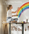 Klicelor 48 x 28 Electric Standing Desk With Memory Presets And Hooks height adjustable, artist painting on spacious dark walnut surface.