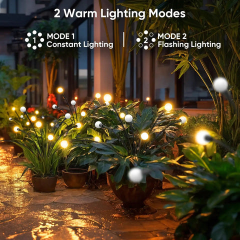 Outdoor Solar Firefly Lights 4 Pack With 32 LEDs Waterproof Pathway Lamps For Yard And Patio Solar Powered Garden Decor That Sways In The Breeze Bright Modern Night Lighting Awesome Gift For Women Moms Friends illuminating a garden pathway at night with warm LED lights.