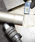 Astro Pneumatic exhaust pipe stretcher kit, metallic, close-up view with digital caliper measuring pipe