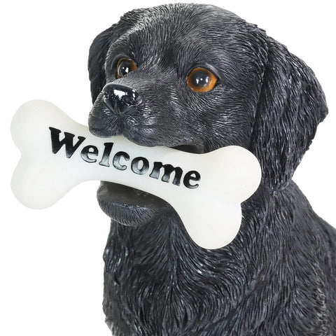 Close-up of Solar Black Labrador Dog Garden Statue With LED Bone Welcome Sign, outdoor resin decor, realistic black lab figurine.