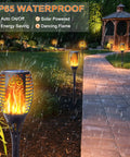 Garden path lit by 8 Pack Solar Torch Lights With Flickering Flame That Looks Lit, Upgraded 3in1 Outdoor Hanging Lanterns.