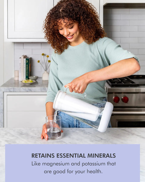 Woman pouring water from a Water Filter Pitcher 7 Cup Glass With Silicone Base Stormy Blue Removes Bacteria Parasites Microplastics Lead Mercury PFAS And A Range Of Chemicals For Everyday Tap Water Protection into a glass