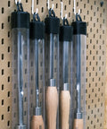 Cryo Treated M2 High Speed Steel Roughing Gouge Three Quarter Inch with solid beech handle displayed in protective tubes on pegboard.
