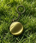 Brass compass with keychain in grass, part of Custom Damascus Steel Folding Knife With Wooden Handle And Separate Compass In Wooden Gift Box Go To EDC Outdoor Knife For Camping Fishing Hunting And Survival Perfect Fathers Day Gift For Dad Or Boyfriend