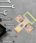 Heavy Duty Sofa Connector Buckles For A Rock Solid Couch Setup next to wrenches, showcasing interlocking iron linkage.
