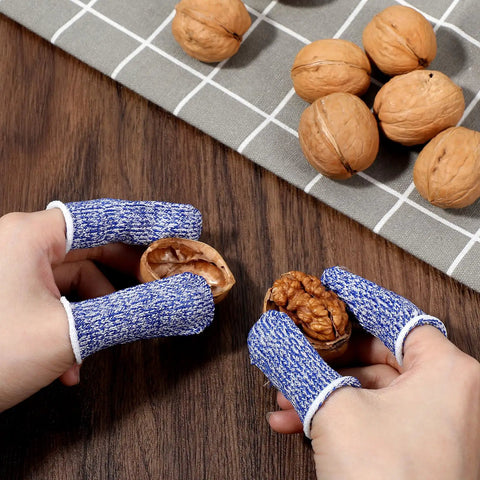 Hands wearing 24 Pack Finger Cut Resistant Protector Gloves Plus Finger Cots Set holding walnuts, showcasing anti-slip fingertip protection.