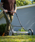 Person using the 18-Inch Push Reel Lawn Mower With 5 Blades, Heat-Treated Alloy Steel Blades, Scissor-Cut Action, in a garden.