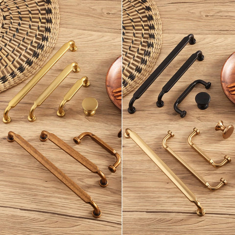 Assorted drawer pulls and knobs, including Antique Brass Zinc Alloy Cabinet Pulls 3 Inch Hole Center 76mm, on a wooden surface.