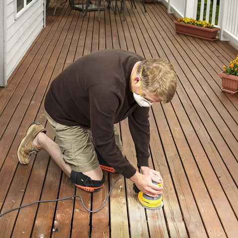 Person kneeling with Heavy Duty Gel Padding Knee Pads With Strong Double Straps For Work, orange color on a wooden deck