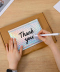 Person writing 'Thank you' on 60 Pack Holographic Bubble Mailers Dope Waterproof Self Seal Foil Glitter Glamour Shipping Envelopes In 3 Sizes For Mailing Jewelry, Makeup, And Small Business Packaging Needs