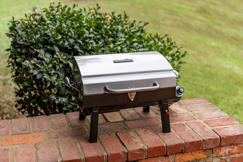 Stainless steel Single Burner Portable Propane Grill With Piezo Ignition on brick surface, ready for outdoor cooking.