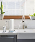 4-In-1 Ceramic Countertop Water Filter System for clean and safe drinking water beside a kitchen sink, ready to use.