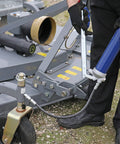 Lincoln 1147 lever-action manual grease gun with blue handle and 18-inch whip hose connected to heavy machinery