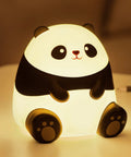 Panda Night Light For Kids With Cozy LED Glow Timer Auto Shutoff Battery Operated Silicone Animal Night Light For Nursery Baby Bedroom Decor Cute Kawaii Gift For Toddlers Boys Girls Teens on a table.