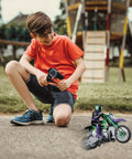 Child playing with Crosslander RC18 Electric Motocross Bike With 2.4 GHz Radio Control Up To 12 Kmph Speed in a park.