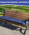 All Weather Outdoor Bench Cushion 48x18x3 Inch Navy Blue Waterproof Seat Pad on wooden bench with metal arms