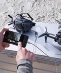 Hands operating smartphone with FPV Drone Bundle With Remote Controller And Goggles Renewed Immersive 150 Degree FOV 4K 60FPS Video setup